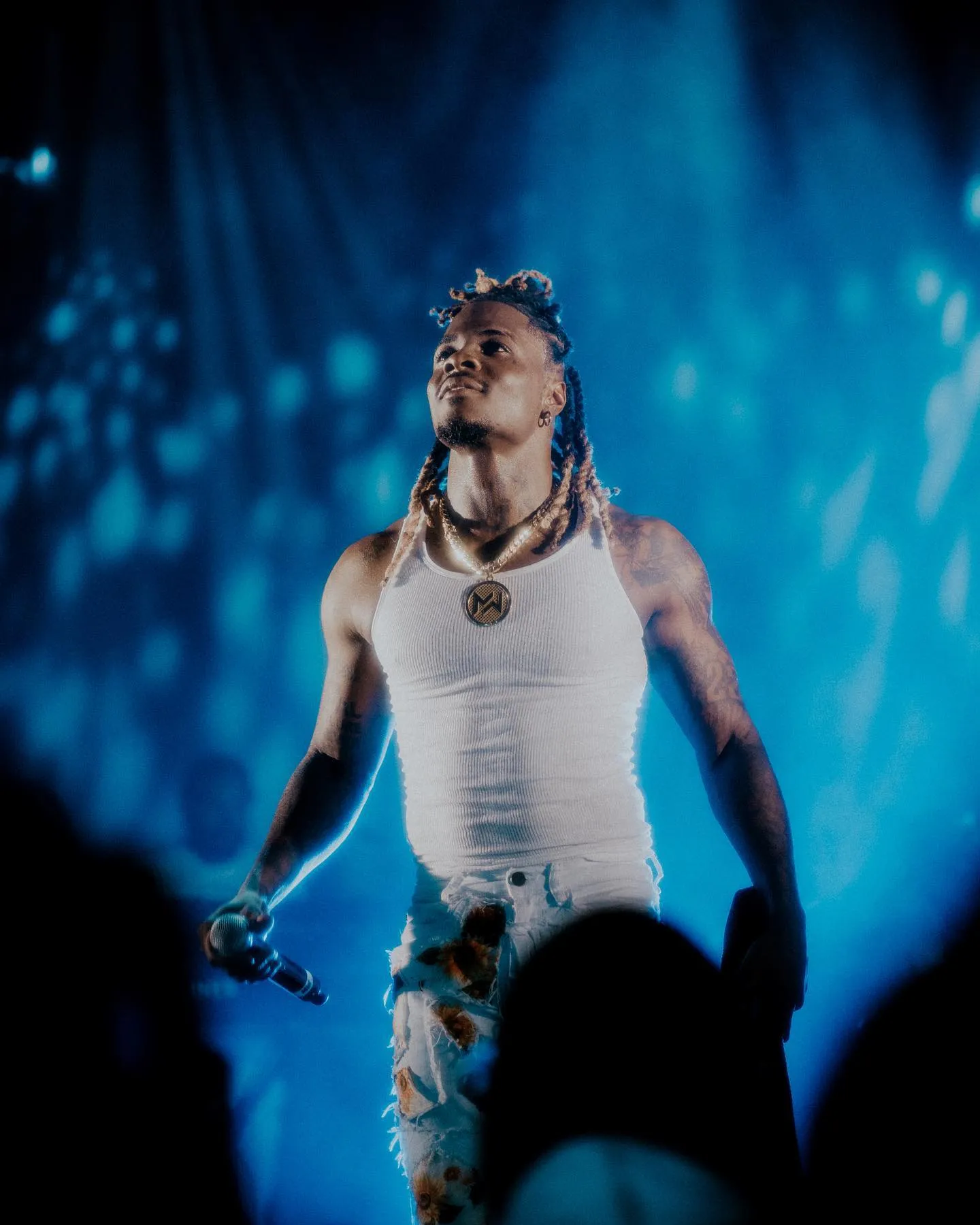 Matieu White debout sur scène sous lumières bleues