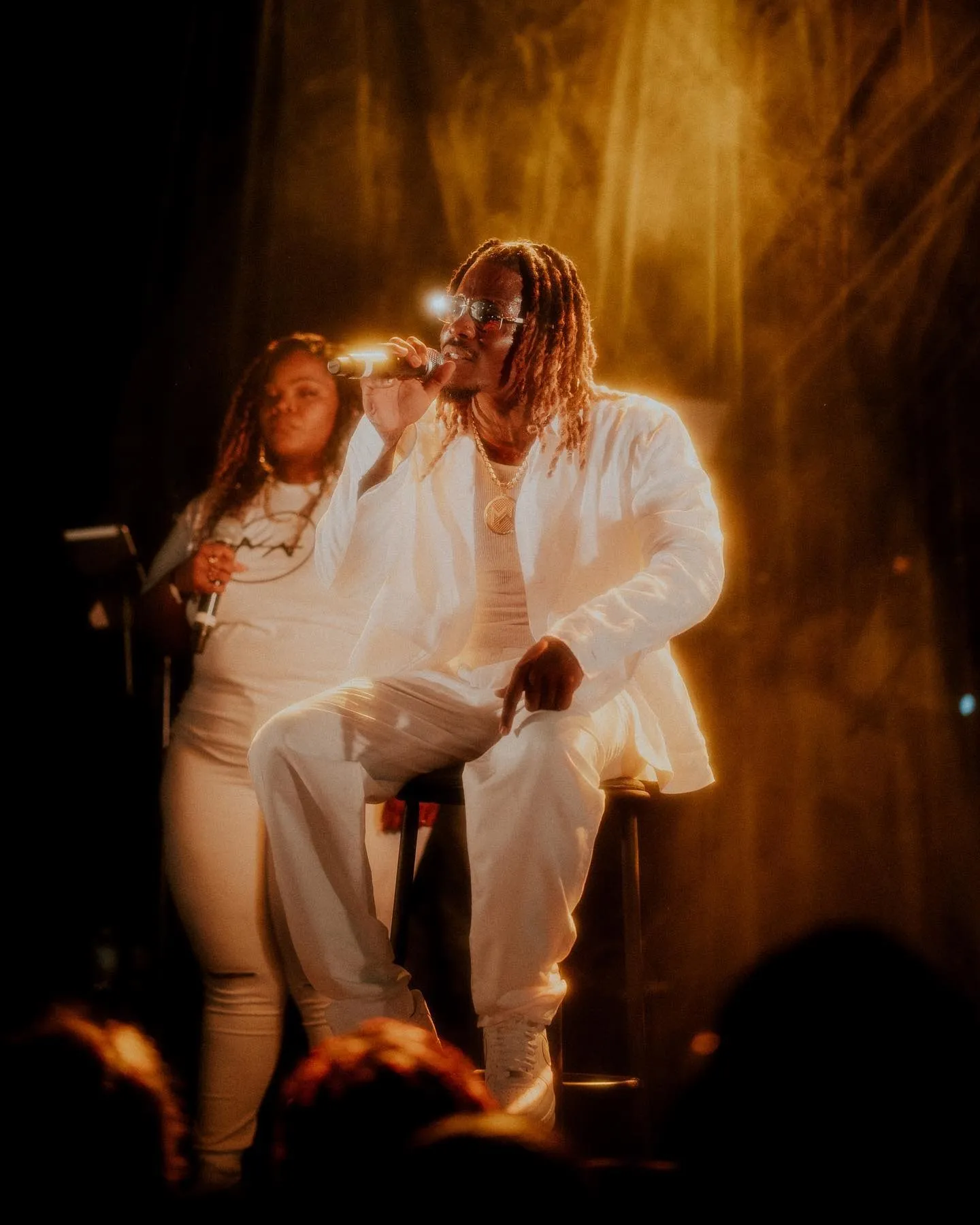 Matieu White chantant en duo sur scène, lumières dorées